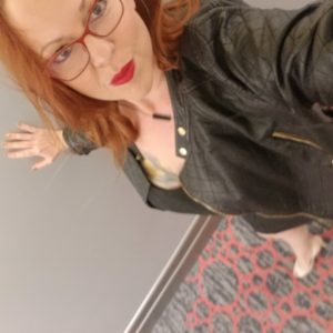 Nikki Ivana, the Las Vegas Masseuse, posing in a black leather jacket