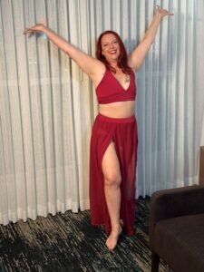 Nikki Ivana standing in a Las Vegas hotel room with her arms open