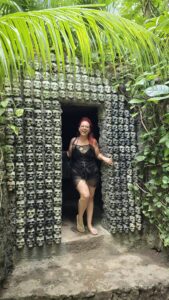 Nikki, Las Vegas GFE escort, posing in a black outfit at a tropical skull-covered doorway in Tulum