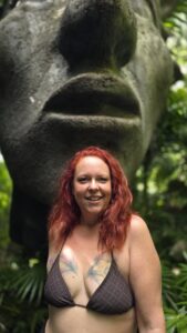Nikki, Las Vegas tantric massage provider, posing in front of a large stone sculpture in Tulum, Mexico